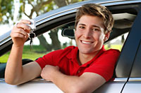 Teenage boy sitting in driver's seat holding keys