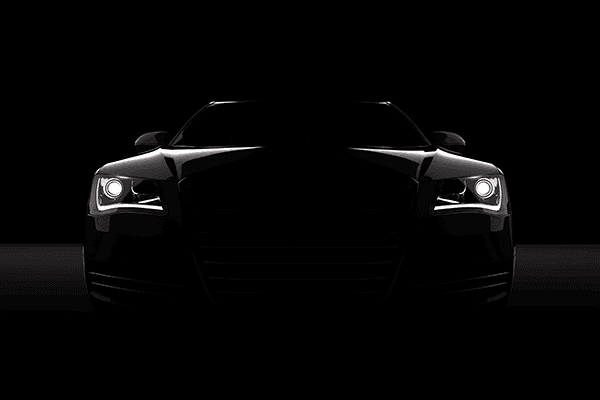 Dark car with headlights getting brighter and brighter.