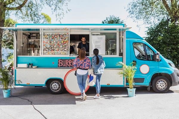 Customers ordering at a food truck window.
