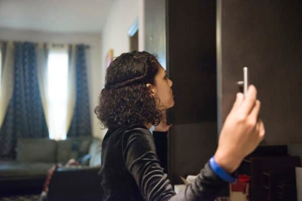 Woman looking inside kitchen cabinets.