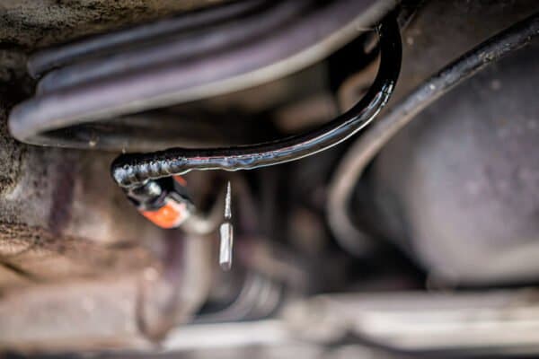 Inspecting wires that run under a car.