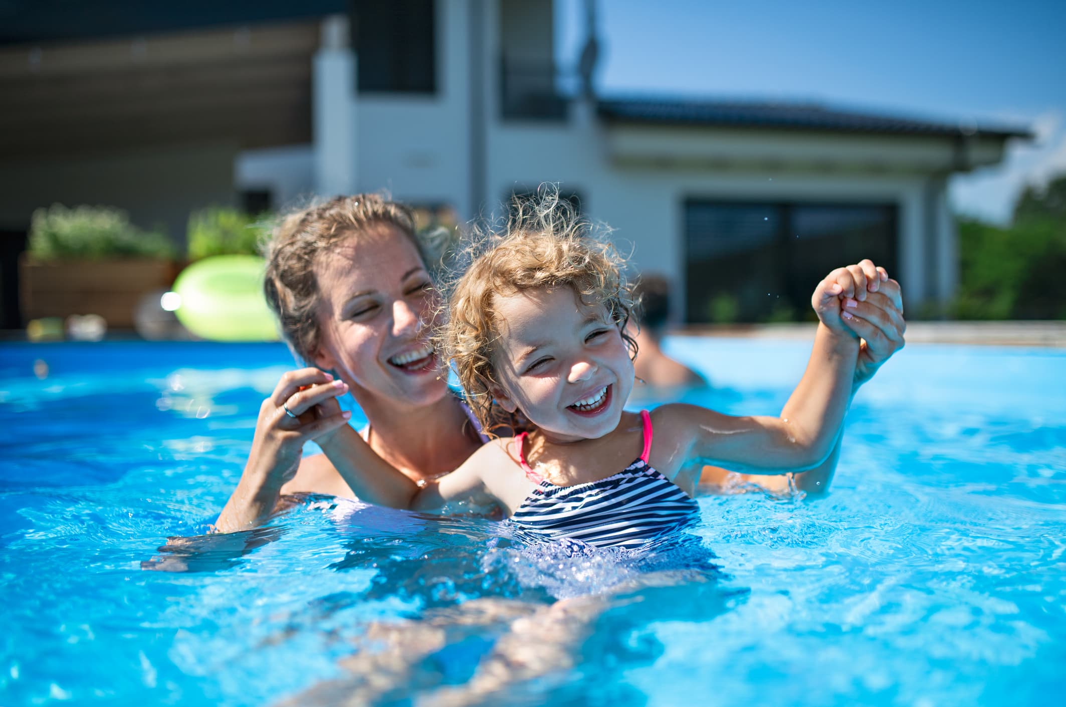 Mother and daughter enjoying their backyard pool, a factor in homeowners coverage.