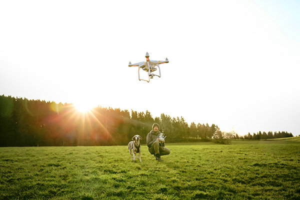 Man and dog flying a drone
