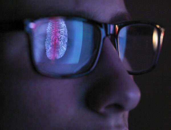 Cyber Security, reflection in spectacles of access information being scanned on computer screen, close up of face