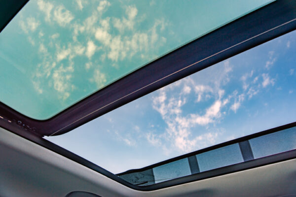 Blue sky through an open car sunroof , view from the passenger compartment,open sunroof look up to sky.