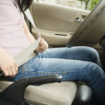 Asian teenager buckling seat belt
