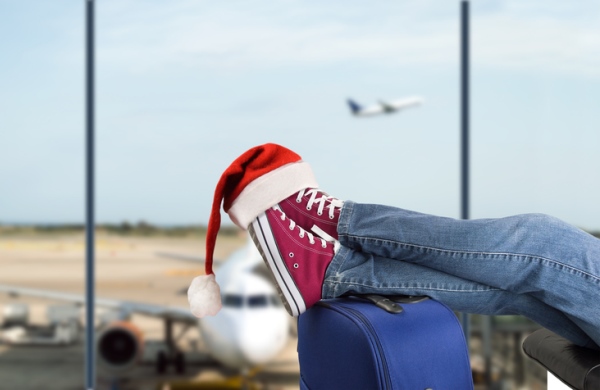 kid's shoes propped on luggage with santa hat on feet