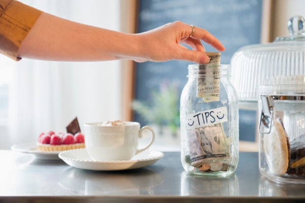 putting money in tip jar