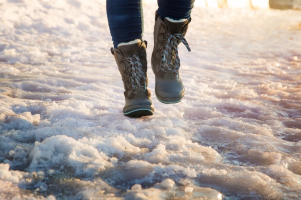 snow boots walking on icy sidewalk