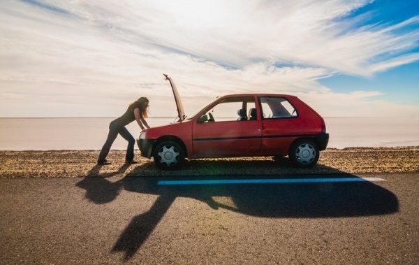 young woman car broken down on beach