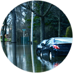 Car driving slowly down a flooded street