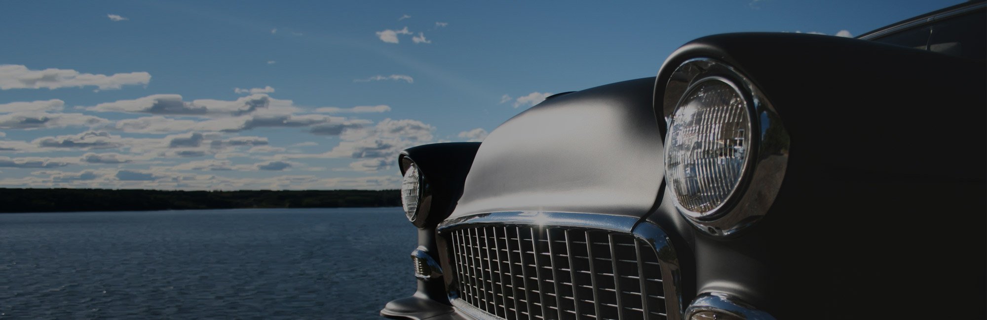 Vintage collector car front end beside a lake illustrating classic car insurance coverage