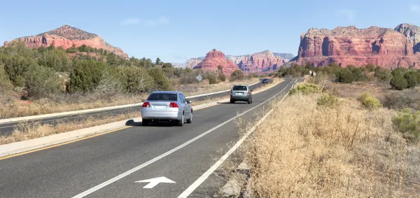 cars driving on an Arizona desert highway with red rock scenery, representing Arizona car insurance needs