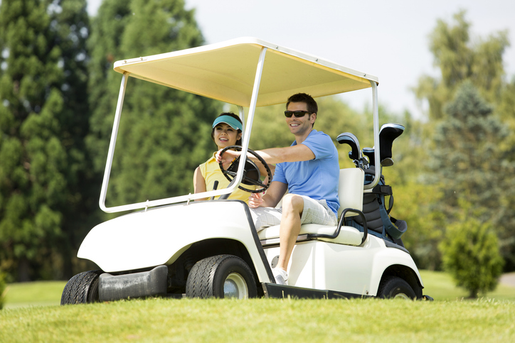 couple driving golf cart used to show the importance of golf cart insurance