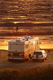 RV and SUV parked together on a beach