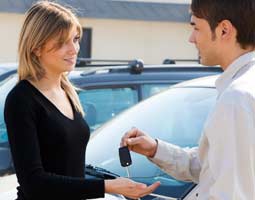 man giving woman keys to a new vehicle