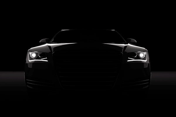 Dark car with headlights getting brighter and brighter.