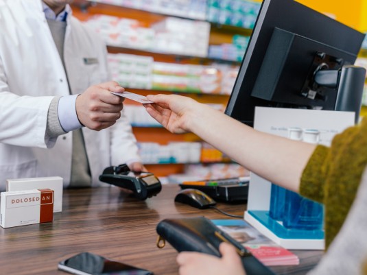 Woman handing credit card to a store clerk.
