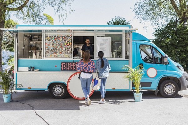 Customers ordering at a food truck window.