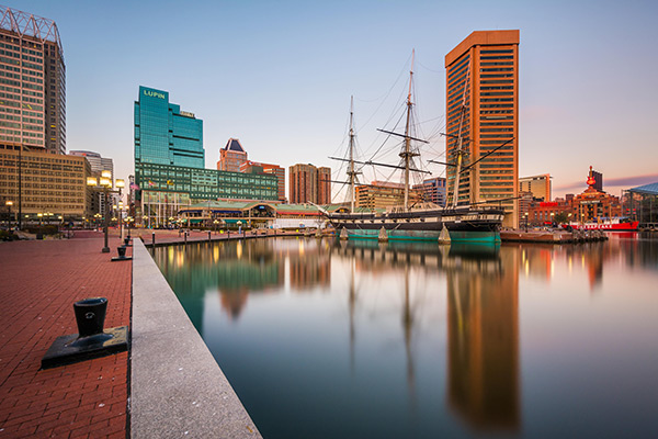 Historic wooden ship docked in a present day city harbor.