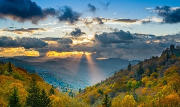 Mountains with the sun rising up behind them.