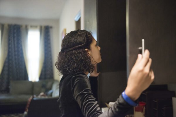 Woman looking inside kitchen cabinets.