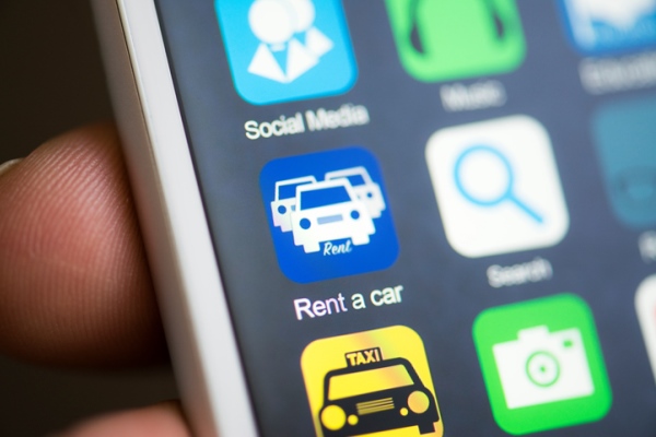 Close up view of the apps installed on a smartphone with a car rental app in focus.