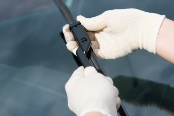 Inspecting wiper blades on a car.