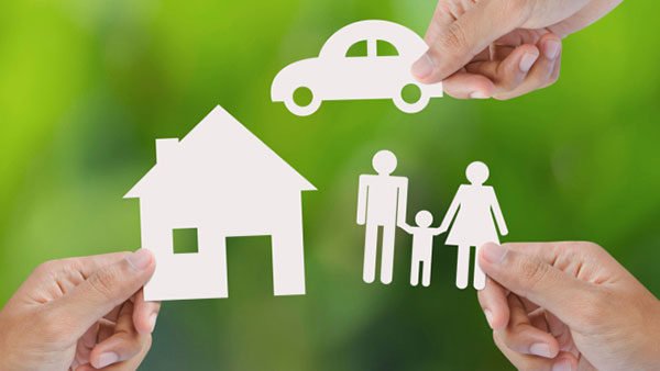 Paper cutouts of a car, a home and a couple holding hands with a child.