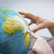 person pointing at a globe