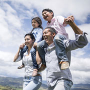 family with parents carrying children on their shoulders