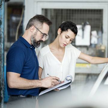 claims adjuster filling out paperwork with customer